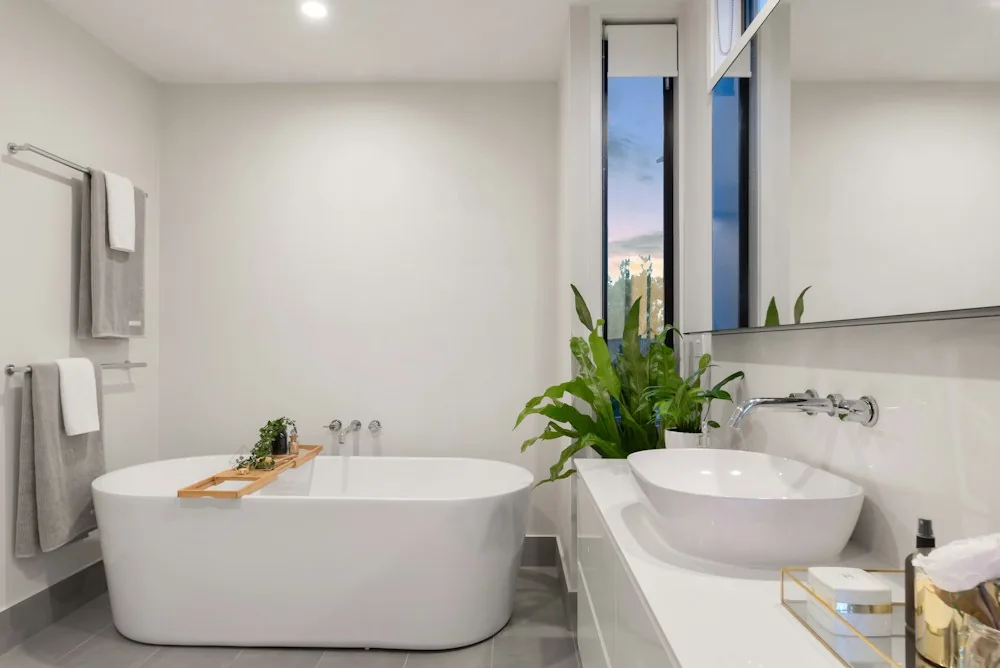 Bright bathroom with a freestanding tub, tiled floor, and white vanity